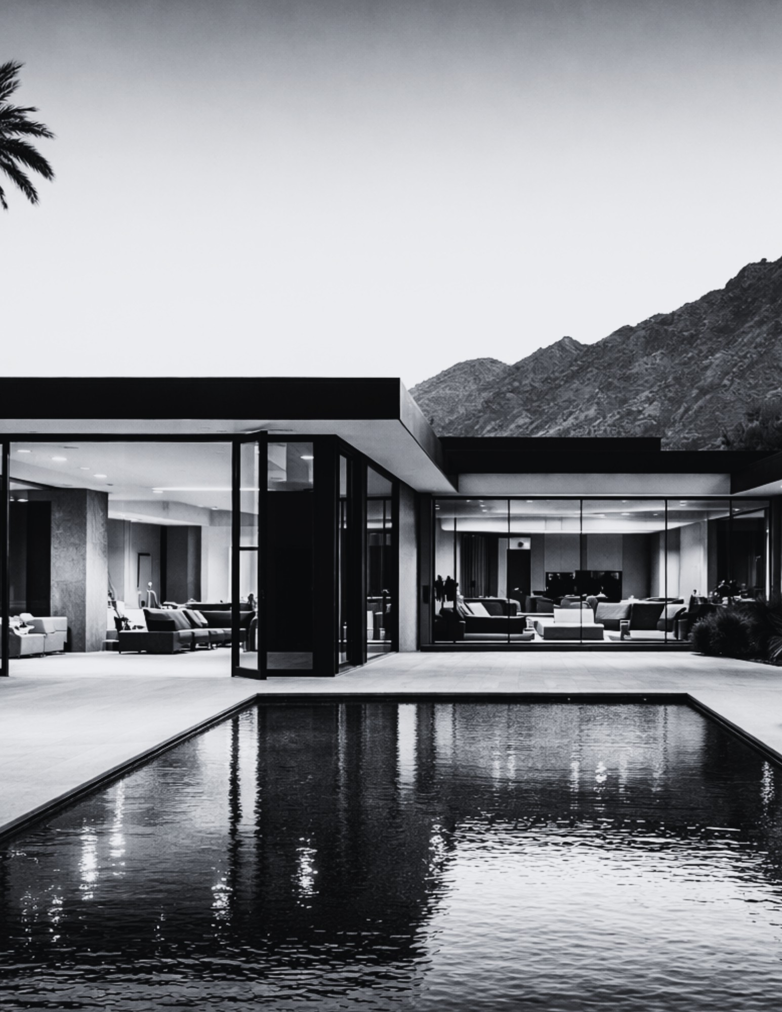 Black & White image of an arizona house modern, from the outside, glass windows with an open wall ot the pool